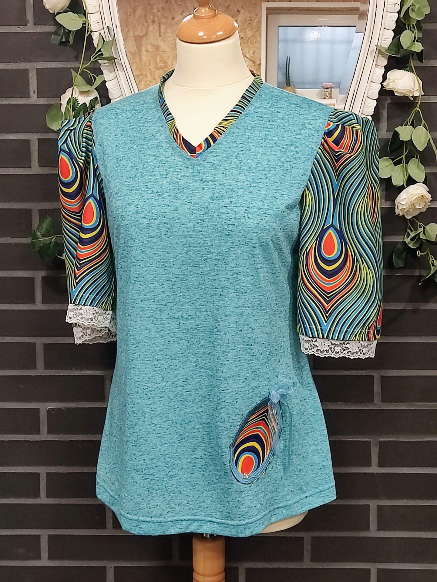 T-shirt para senhora em algodão azul com mangas em balão feitas em capulana com desenho de penas de pavão, disponível em vários tamanhos