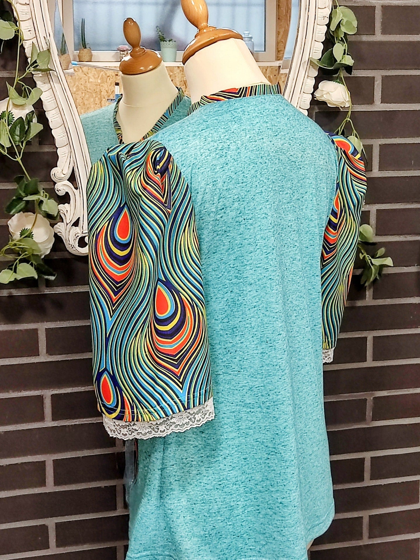 T-shirt para senhora em algodão azul com mangas em balão feitas em capulana com desenho de penas de pavão, disponível em vários tamanhos